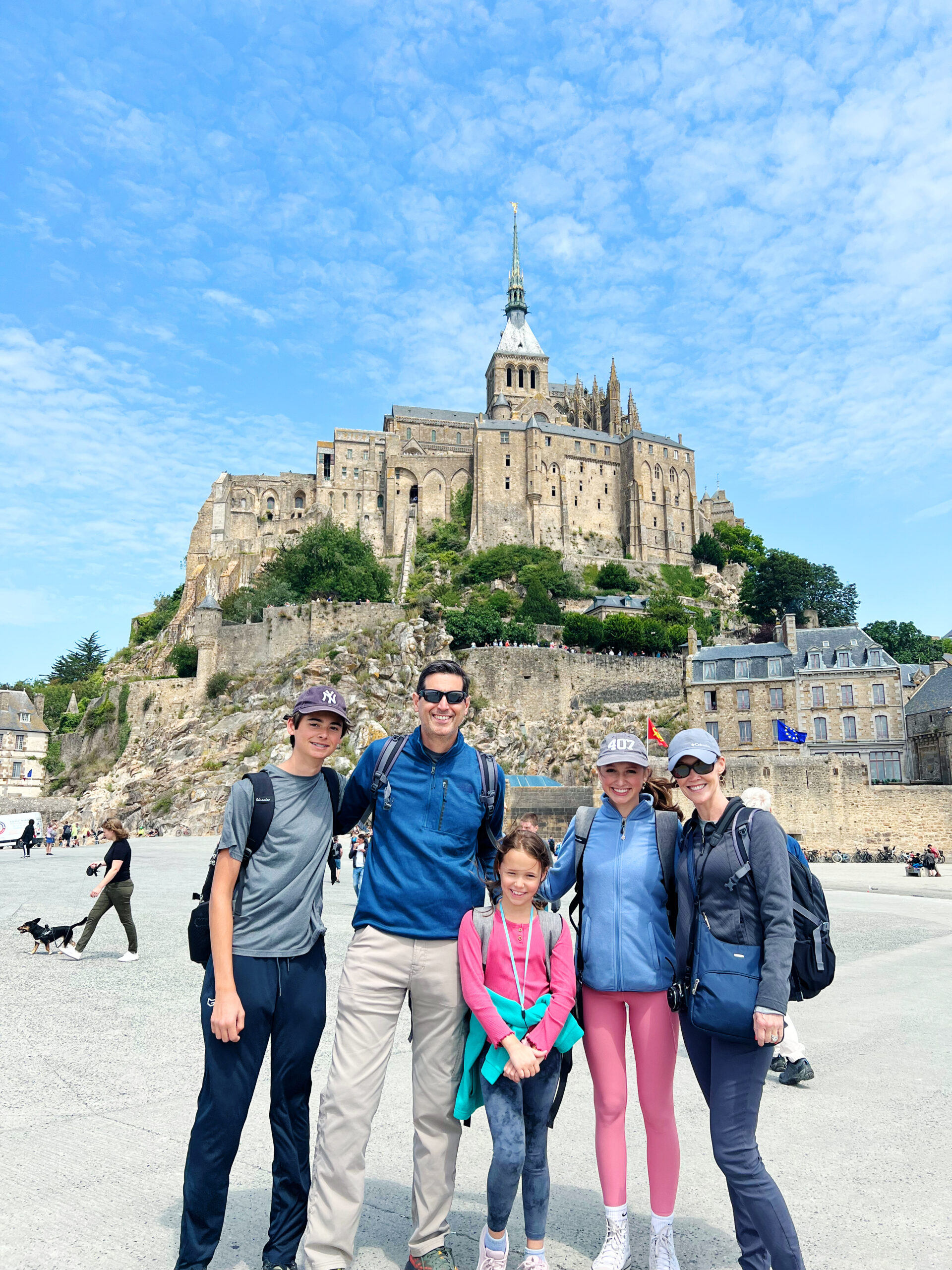 A family of five standing in front of the historic Mont Saint-Michel in France