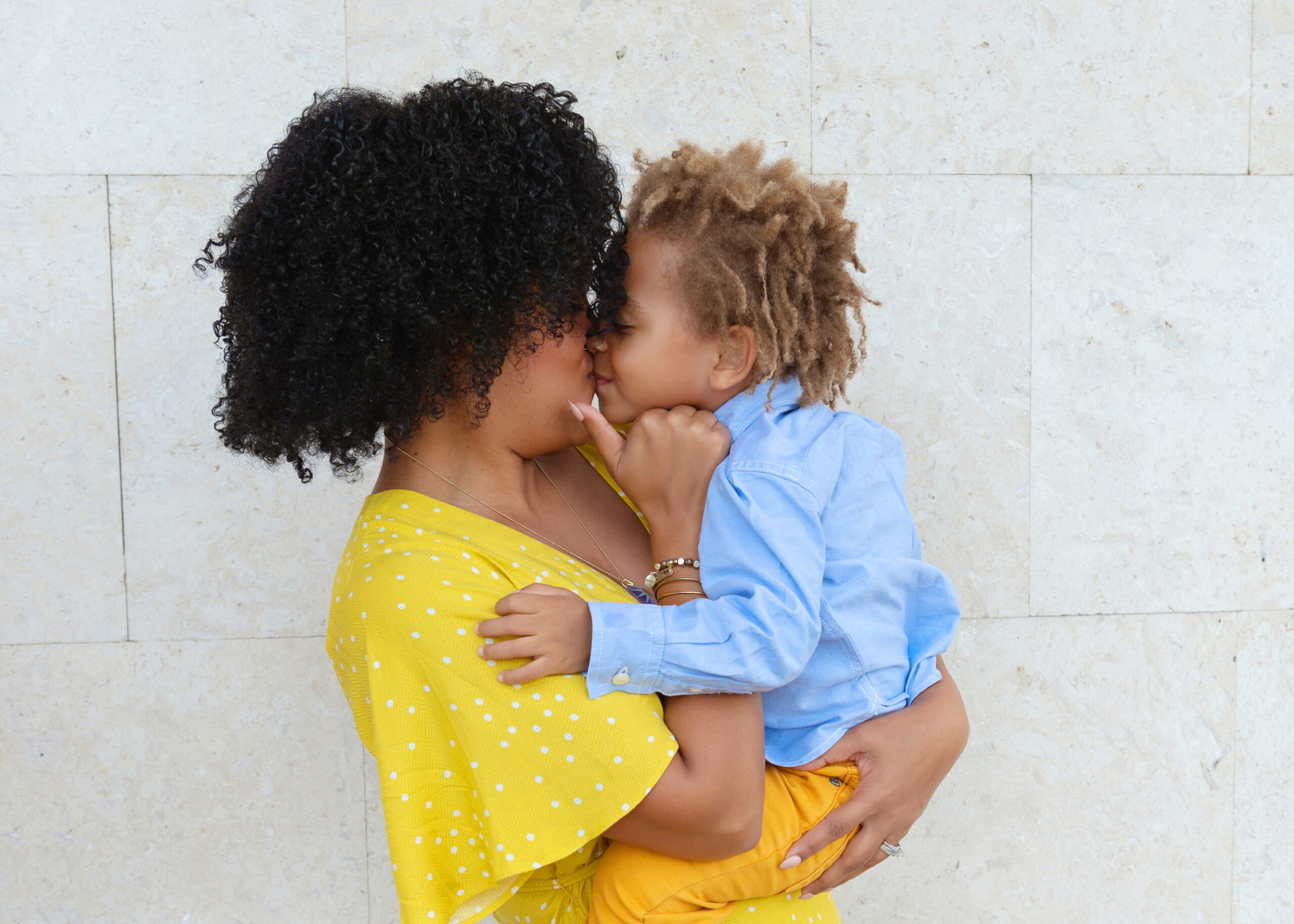 A tender moment between a mother and her son as they share a loving kiss.